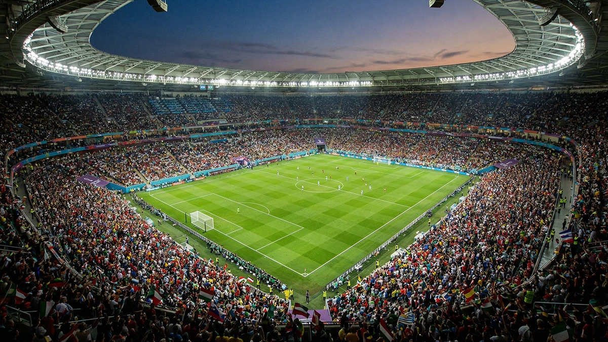 Vue plongeante d'un grand stade international rempli de drapeaux de différentes nations lors d'un match